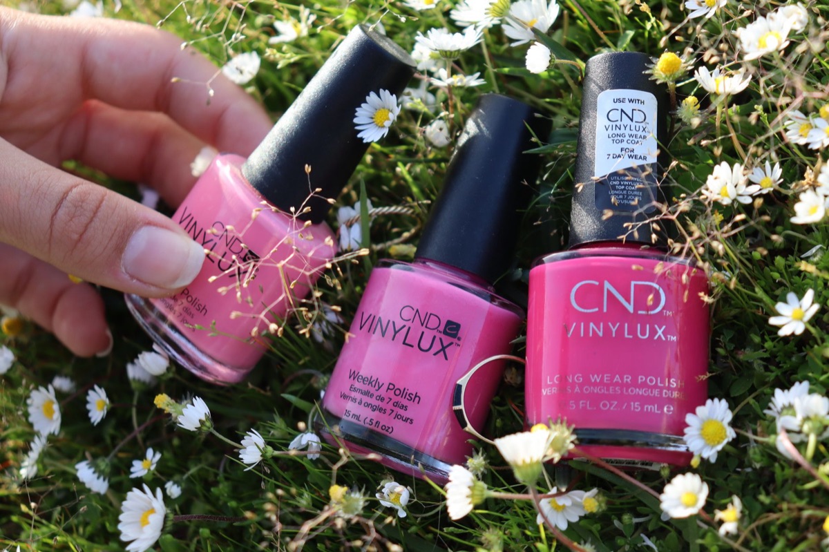Diverse kleuren nagellak flesjes en manicure tools op een witte achtergrond.