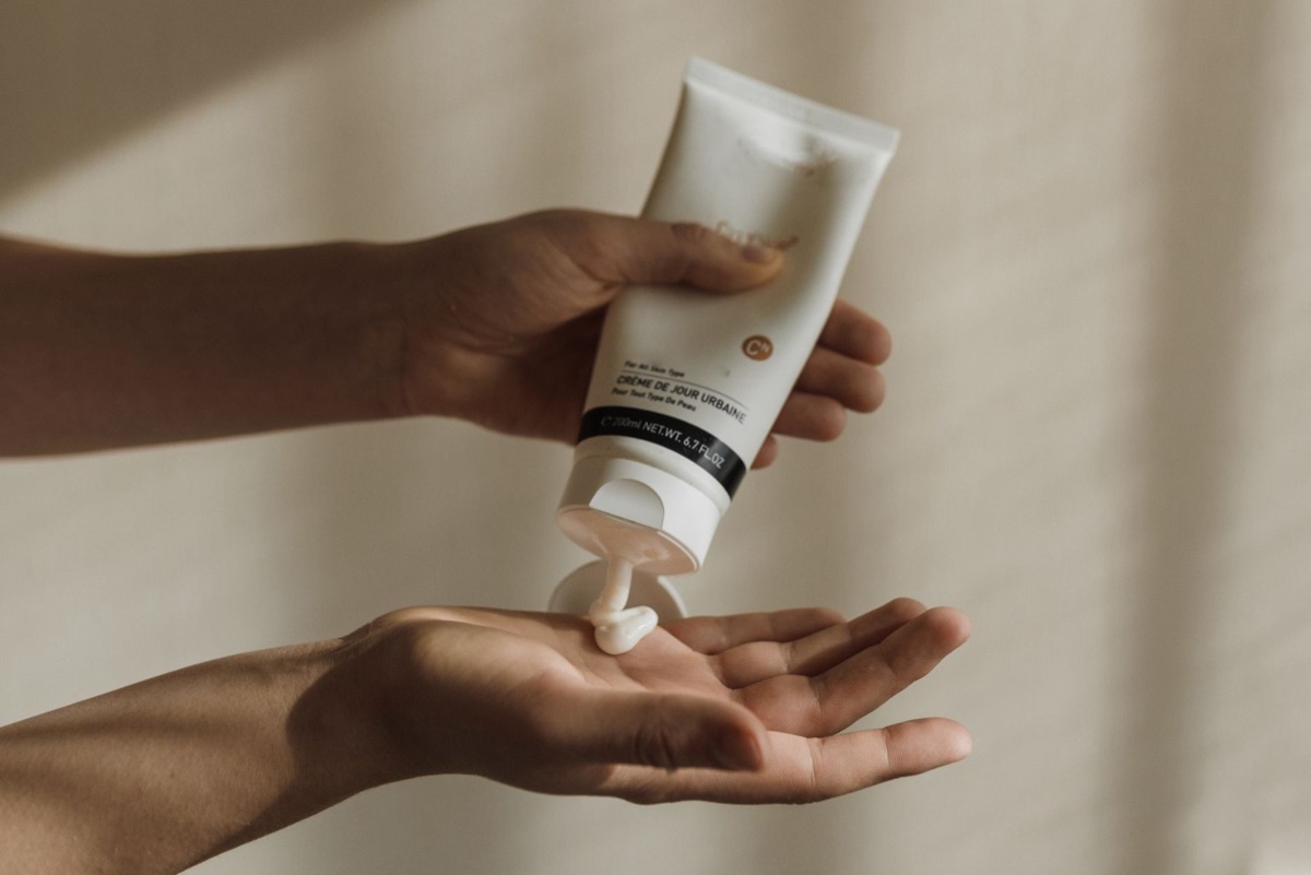 Mãos sendo hidratadas com creme para mãos para manter as cutículas saudáveis.