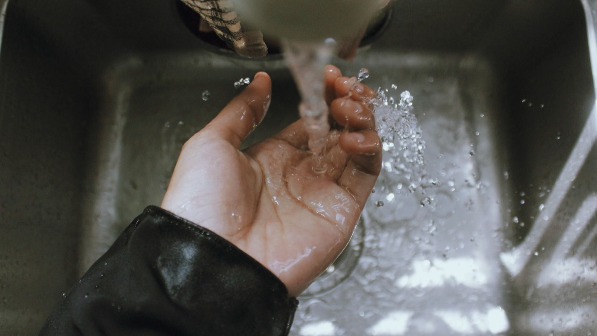 Hands soaking in warm water for manicure preparation