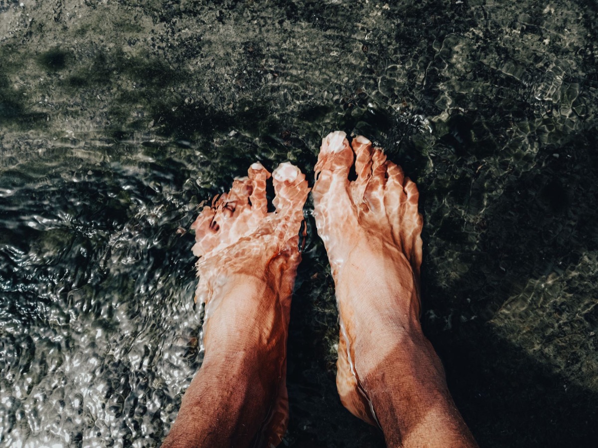 Mani immerse in acqua calda per il trattamento