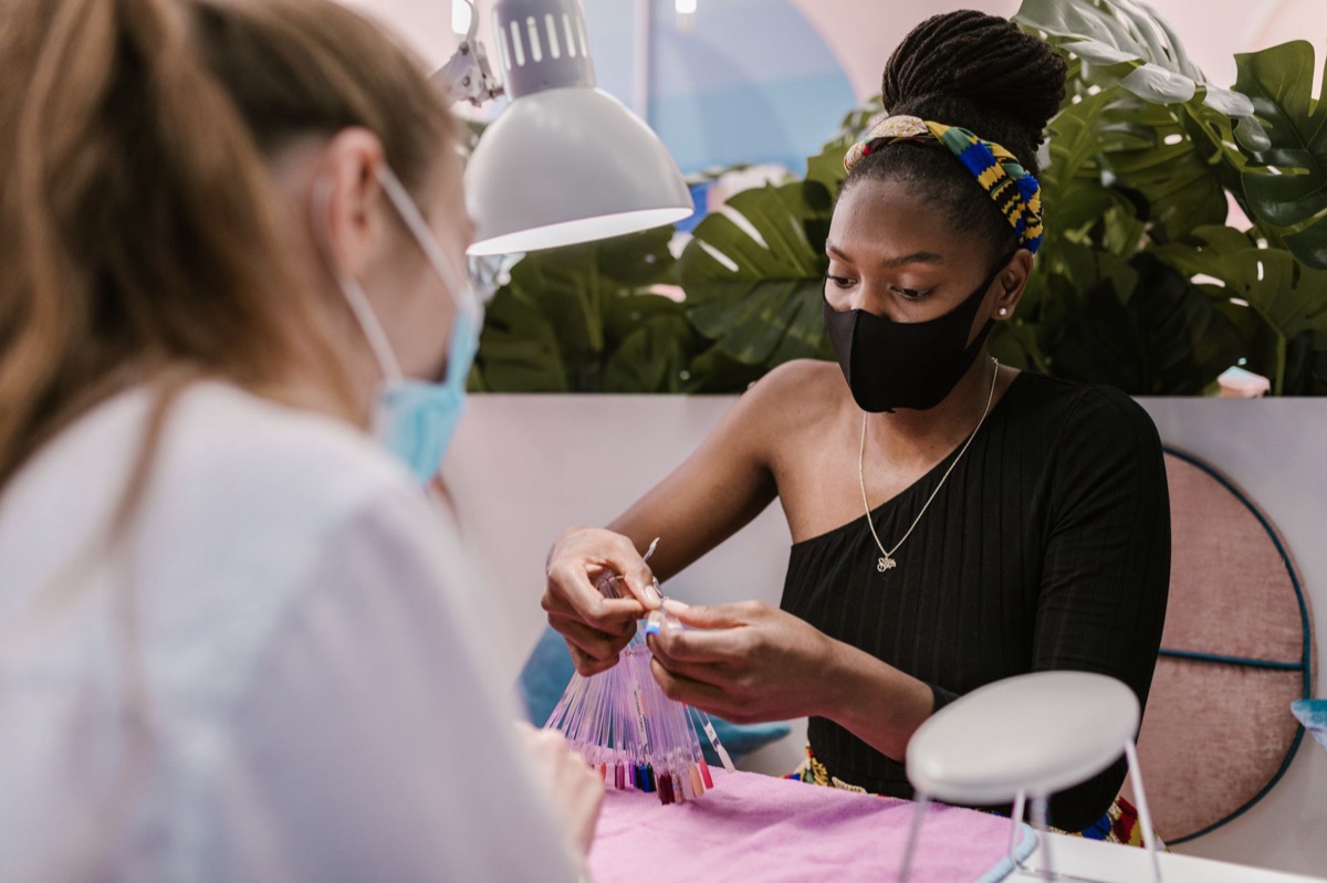 Nail technician with tools and clients